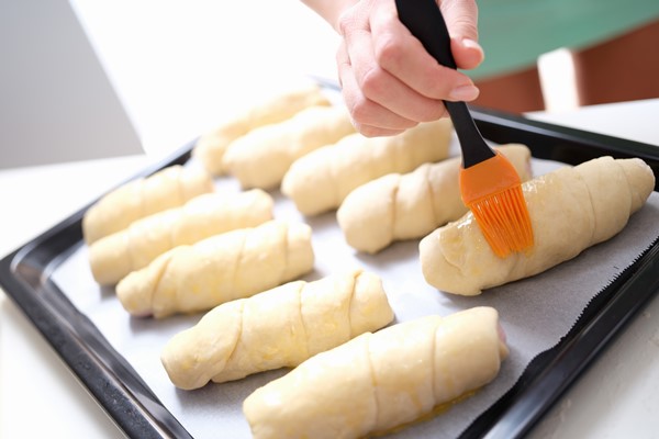 chef brushes raw croissants with brush in yolk cooking process - Рогалики по ГОСТу