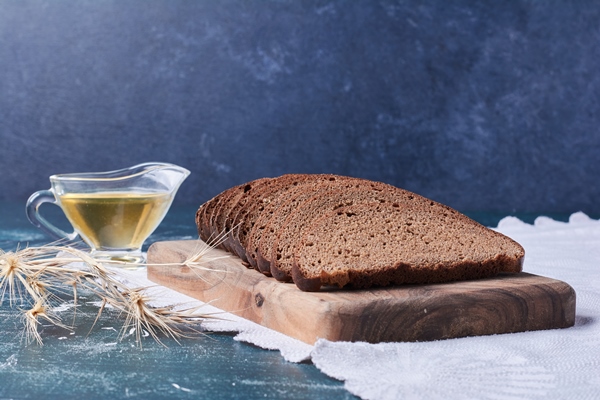 dark bread slices with oil on blue table - Хлеб бородинский штучный, высший сорт