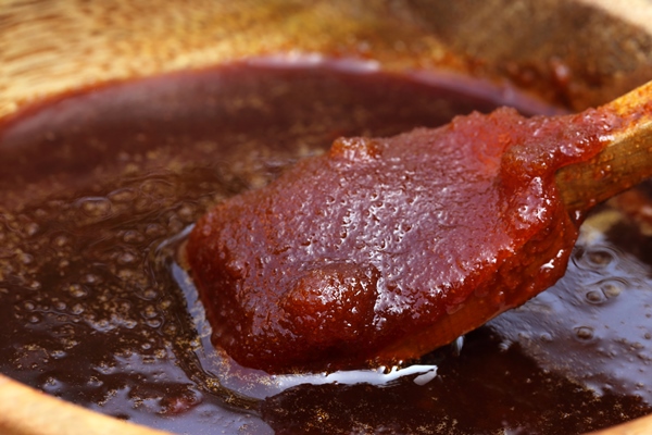 date molasses on wooden bowl with spoon - Минский хлеб
