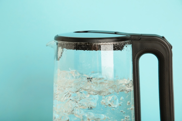 glass electric kettle with boiling water on blue background - Ржаной заварной хлеб