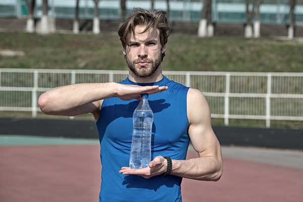handsome man or guy with muscular body holds plastic refreshing water bottle sunny outdoor in blue sportswear at stadium fitness and healthy lifestyle concept - Пирамида питания