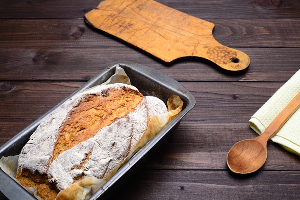 homemade bread dough in proofing basket on wooden table with flour cumin and wheat ears copy space - Ржаной заварной хлеб