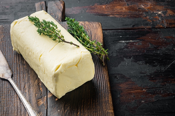 pat of farm fresh butter on old dark wooden table background with copy space for - Кисло-сладкие хлебцы
