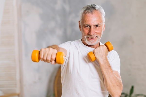 portrait of happy senior man lifting weights - Средиземноморская диета
