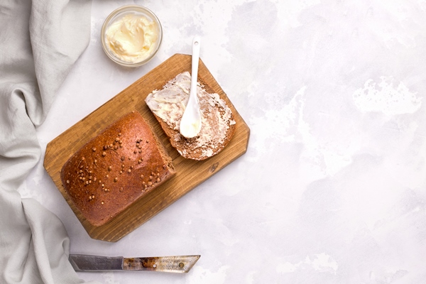 borodino bread on a white plate with butter copy space - Бородинский хлеб: история и современность
