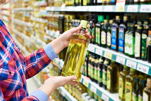 buyer with the sunflower oil in a store - Оливковое масло