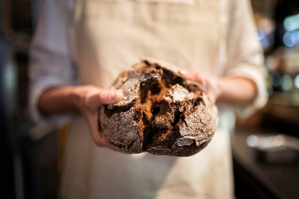 close up baker holding bread - Бородинский хлеб: история и современность