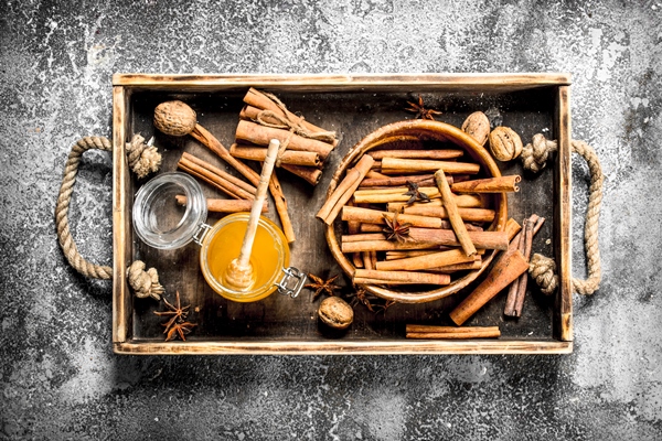 fresh honey with the cinnamon sticks in a bowl on rustic background - Традиционные напитки сочельника: узвар, плодово-ягодный кисель