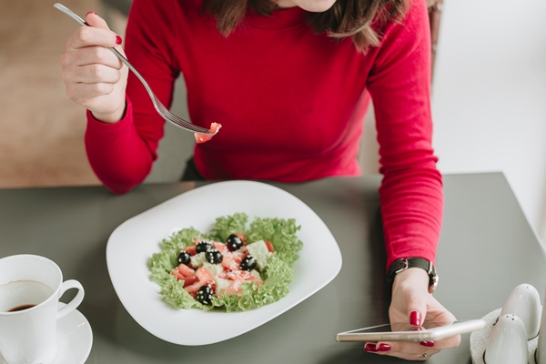 girl eating a salad in a restaurant - Польза и вред оливок