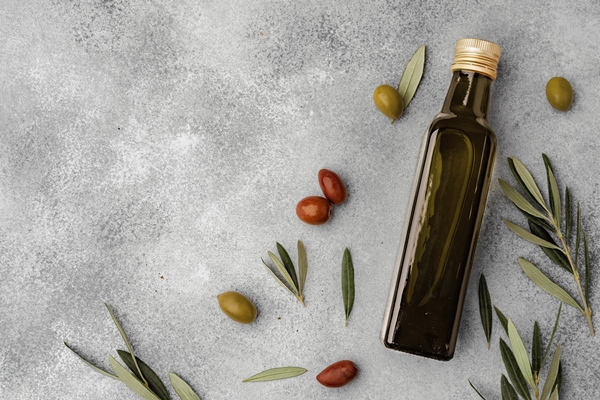 glass bottle with olive oil on gray background - Оливковое масло