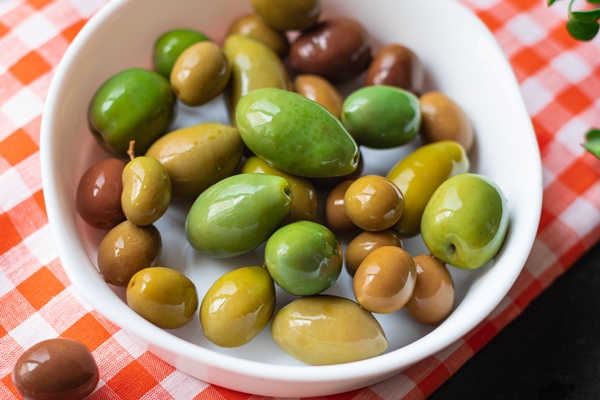olive pitted plate on the table varieties fruits vegan vegetarian food - Использование оливок в кулинарии