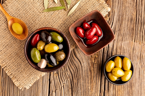 olives in bowls and wooden spoon on textile material - Оливки и маслины: в чём разница