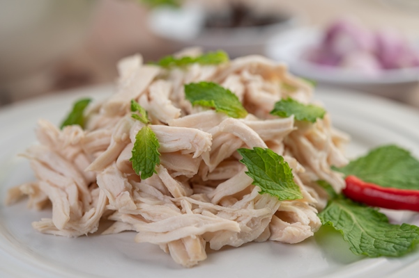 the chicken that is bordered is cooked and placed in a white plate along with mint leaves - Салат "Оливье" (старинный рецепт)