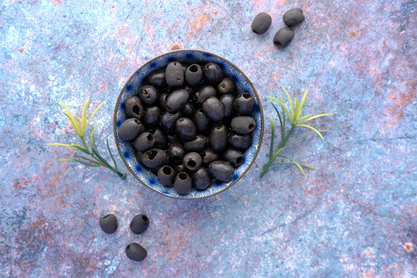 top view of black color olive in a bowl on table - Оливки и маслины: в чём разница