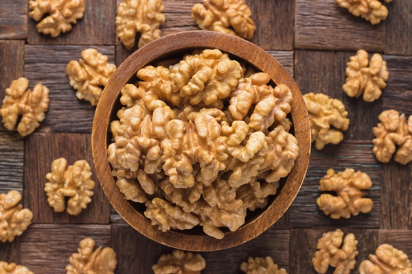 walnut peeled in wooden bowl top view - Продукты против вирусов