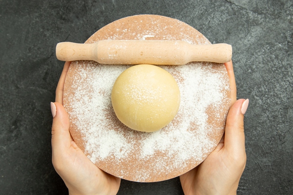 top view raw round dough with flour on a grey desk dough raw meal flour food - Уральские пельмени