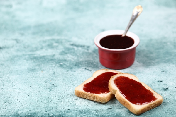a cup of red jam with two slices of bread - Варенье из еловых шишек