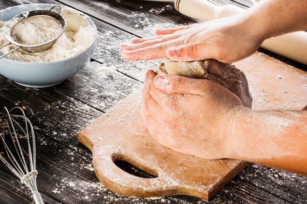 close up of baker s hand kneading bread dough - Постная галета с мандаринами