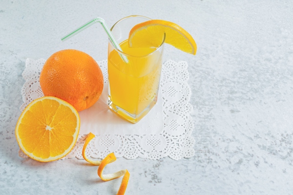 close up photo of half cut or whole fresh orange with glass of juice on grey wall - Галета с ревенем