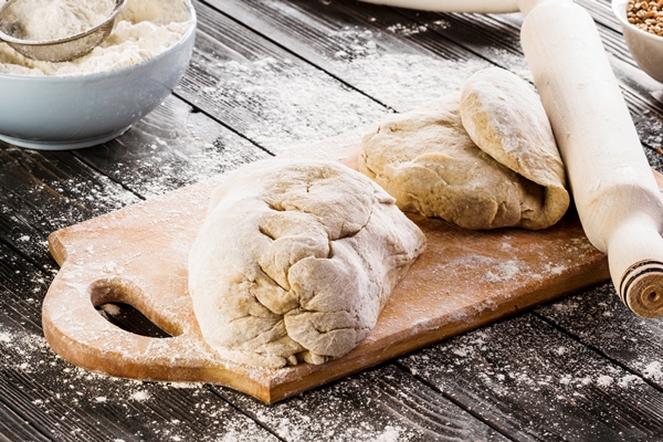 kneaded dough on chopping board with rolling pin - Постная цельнозерновая галета с лимонной начинкой
