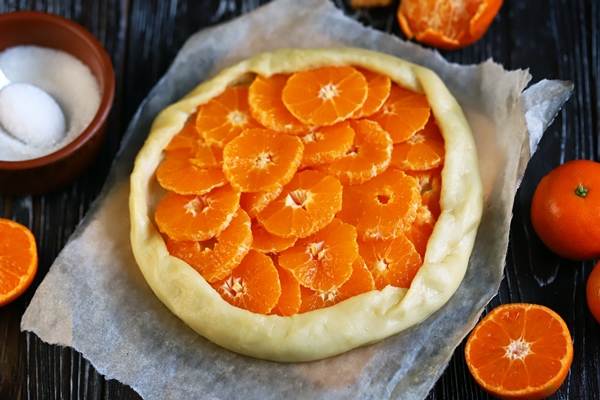 selective focus mandarin galette before baking cooking citrus galette - Постная галета с мандаринами