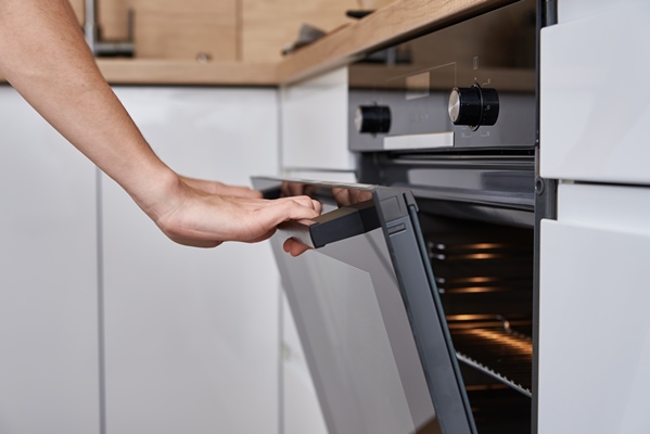 woman hand open electric oven door with handle homemade cooking kitchen appliance - Постная цельнозерновая галета с лимонной начинкой