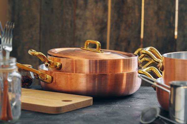 copper cookware with wooden kitchen utensils close up - Как правильно варить и хранить варенье