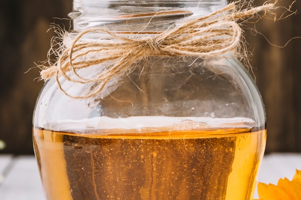 jar of honey with beautiful flowers on wooden surface 1 - Яблочный уксус из сока