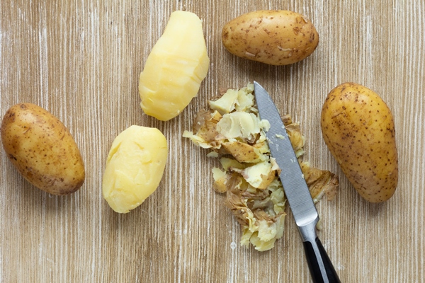 top view of boiled potatoes in jackets and scrubbed on the wooden background - Яблочно-свекольная окрошка