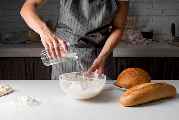 woman pouring water dough - Постное слоёное бездрожжевое тесто