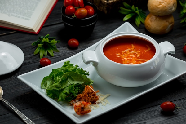 a white bowl of tomato soup with chopped parmesan and green salad - Сухая томатная паста