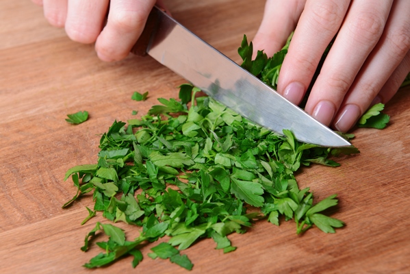 chopped parsley on wooden board closeup - Рулет из лаваша с творогом, сыром и зеленью