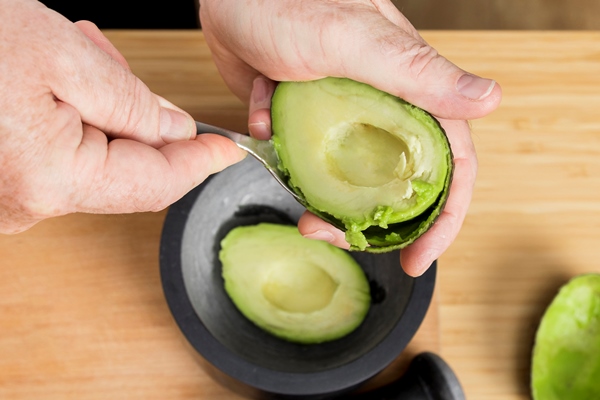 close up chef cleaning avocado - Бутерброд с авокадо и яйцом