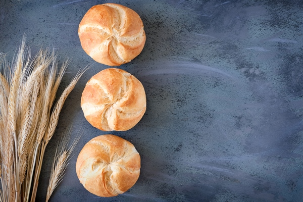 crusty round bread rolls known as kaiser or vienna rolls with a bunch of wheat ears on grey background - Хот-доги "Собачки"