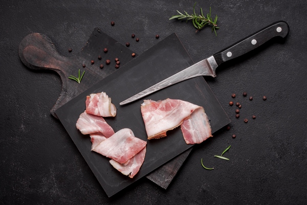fresh uncooked bacon on wooden board with knife - Хозяйке на заметку: виды кухонных ножей