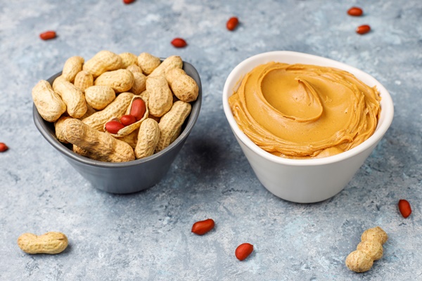 homemade peanut butter with peanuts on grey concrete table top view - Тосты для детей на завтрак