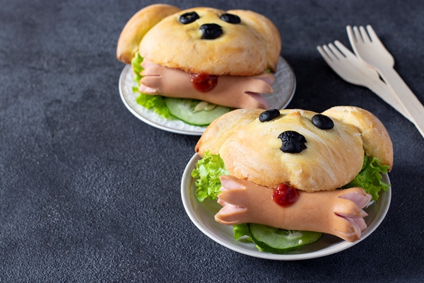 sandwiches in the shape of a dog with a sausage on dark gray background cooking idea for kids space for - Хот-доги "Собачки"