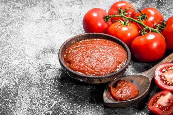 tomato sauce in a wooden bowl on rustic background - Сухая томатная паста