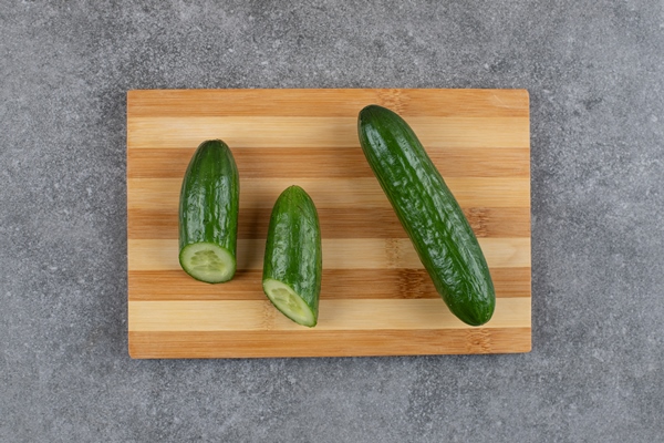 top view o fresh organic cucumbers on wooden board - Салат с консервированным тунцом, яйцом, зелёным луком и огурцом