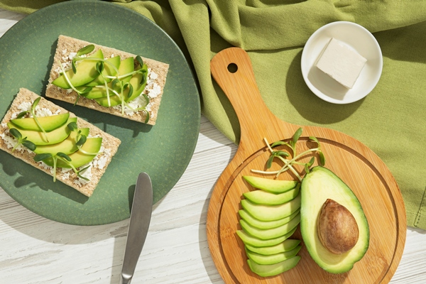 top view of plate with keto diet food and avocado - Яйцо пашот с авокадо и зерновым хлебцем