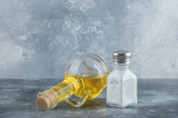 bottle of oil and salt on grey background - Салат из свежих помидоров и огурцов (школьное питание)