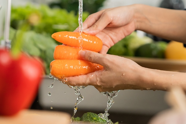 close up asian young woman washing carrot tomato broccoli fresh vegetables paprika with splash water in basin of water on sink in kitchen preparing fresh salad cooking meal healthy food people - Салат из белокочанной капусты (школьное питание)