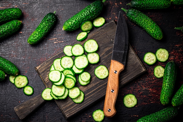 cucumbers cut on a cutting board - Салат из капусты с огурцами и помидорами (школьное питание)