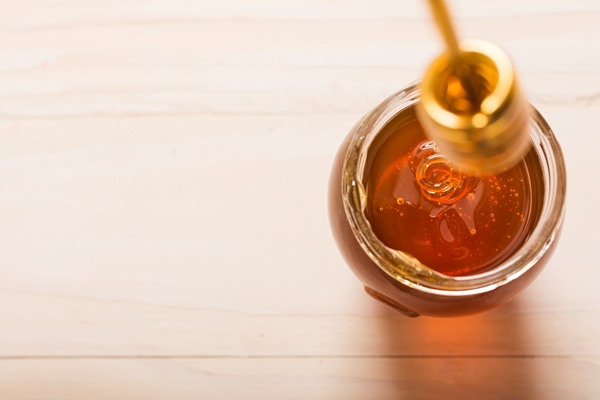 glass jar full of honey with honey spoon - Куркума-латте