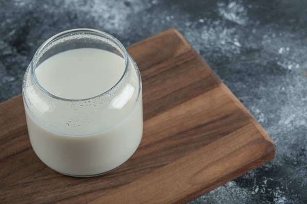 glass of fresh milk on wooden board - Финиковый латте