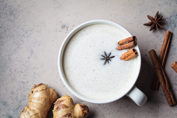 homemade chai latte with cinnamon and star anise in white cup dark background - Финиковый латте