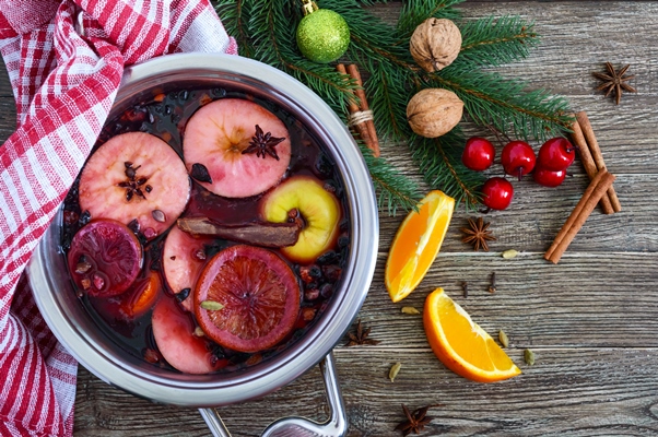 hot mulled wine in a large pan on a wooden table fragrant traditional winter drink based on wine juice spices seasonings fruits top view - Пунш безалкогольный