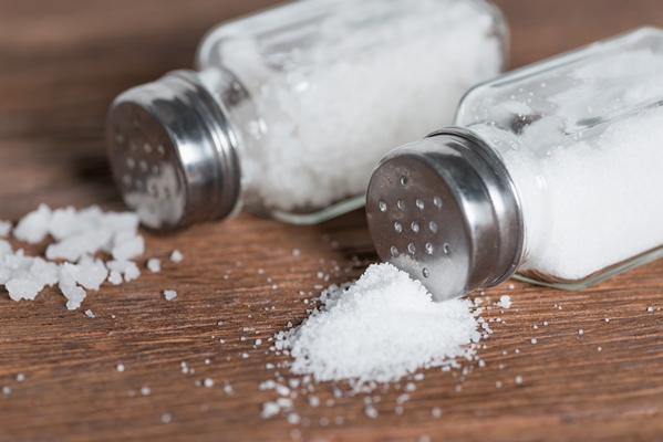 salt in salt shaker on dark wood background - Горячая карамель
