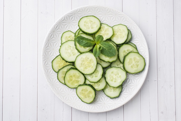 sliced cucumber with mint on a plate - Огурцы, помидоры, перец болгарский в нарезке (школьное питание)