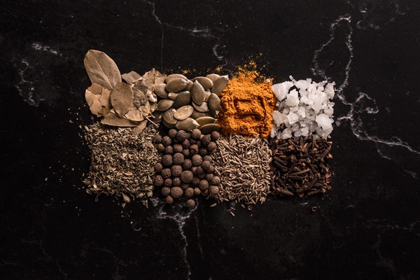 vertical shot of spices and seeds on black background - Пряный Флэт Уайт